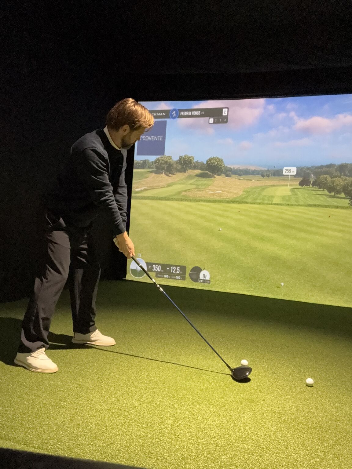 Fredrik Henge förbereder ett slag i golfstudion